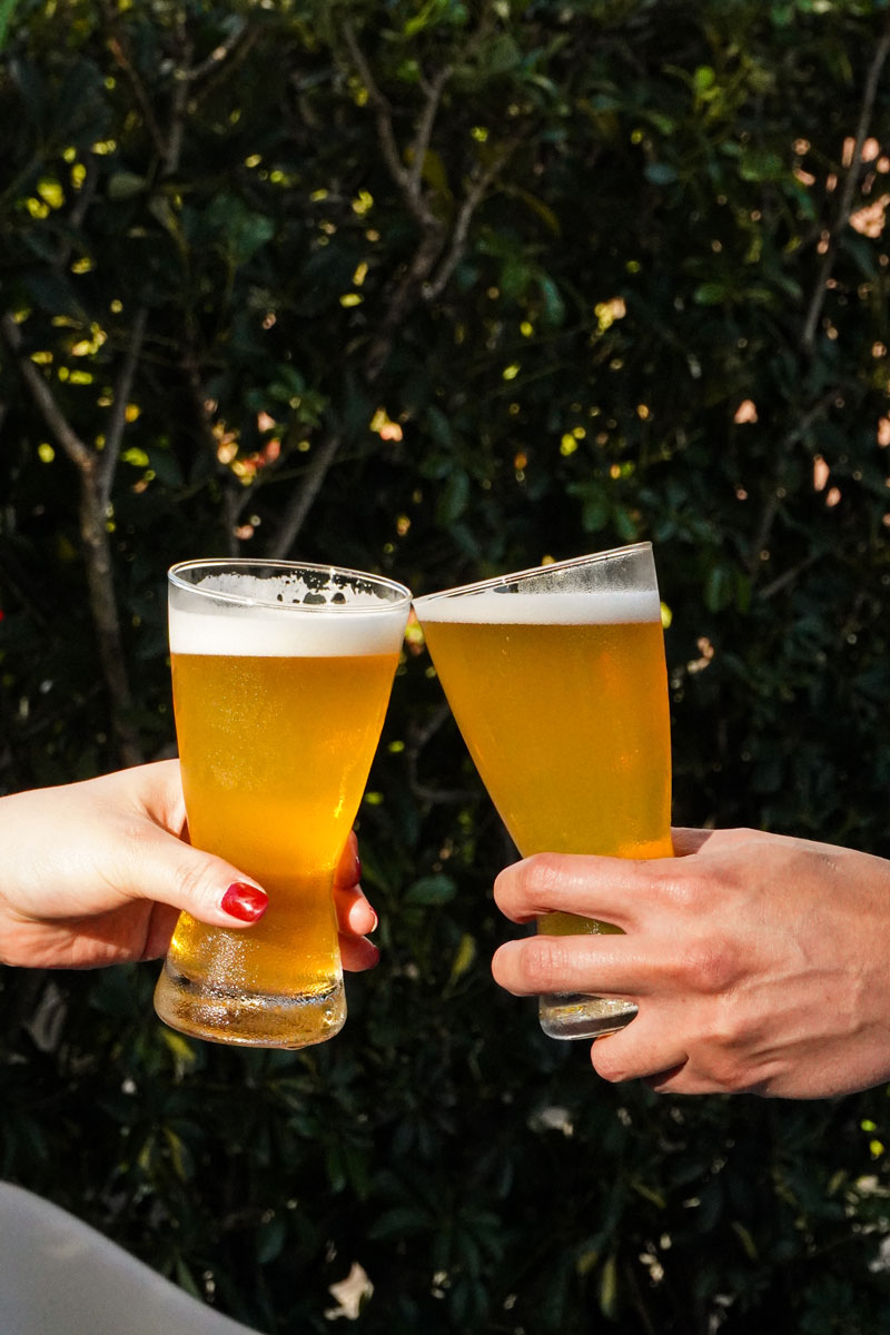 Two glasses of beer toasting at Il Forno happy hour